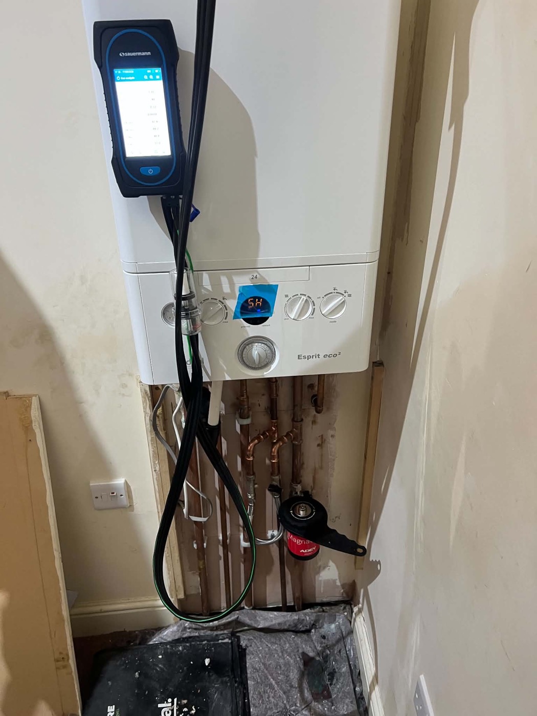 Boiler connected to gas analysis equipment with pipework and magnetic filter below
